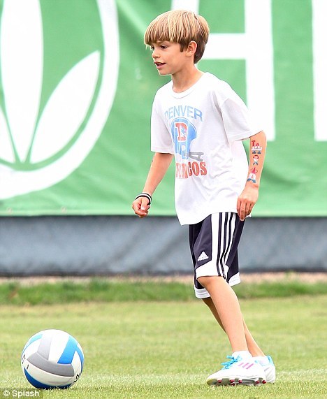 Romeo Beckham shows off some temporary tattoos on his left arm