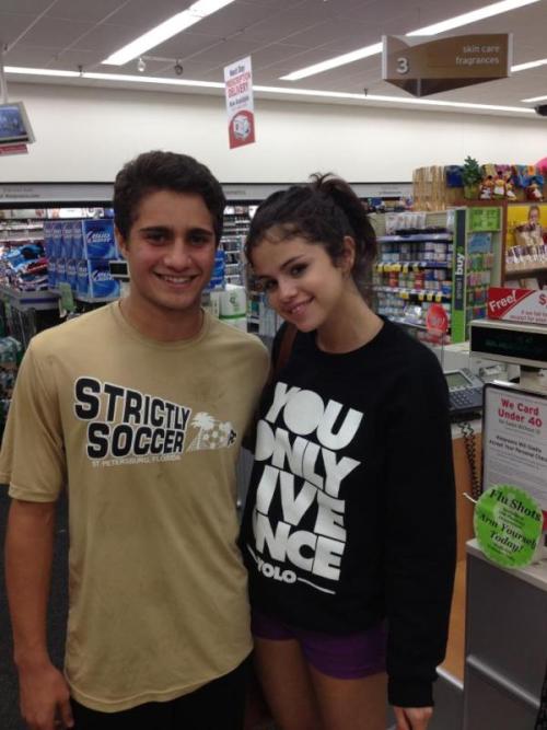 Selena with a fan Wednesday in Walgreens! She bought his girlfriend a get-well card and signed it!