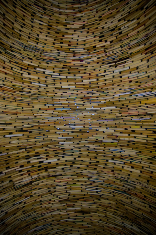 Image - photo of a curved wall made out of BOOKS stacked like bricks. There would have to be hundreds and hundreds of books in this wall! Or&#8230; maybe they&#8217;re built on a mirror? There is some distortion on the top and bottom of the photo.
TIMES WHEN I SUCK AT DESCRIBING PHOTOS!